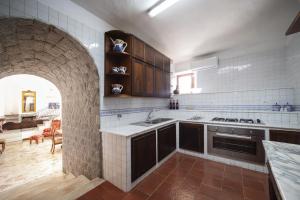 a kitchen with a stone archway and a stove top oven at villa il sogno di Cosimo in Ravello