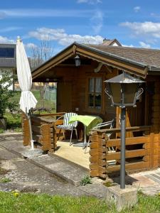 a house with a deck with a table and an umbrella at Villa Margot in Schrems