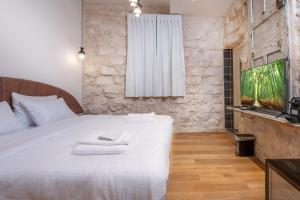 a bedroom with a white bed with towels on it at El Khan Guesthouse & Art - A Complex of 4 Middle Eastern-Style Suites in Nazareth