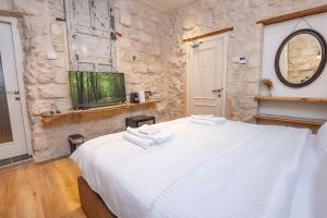 a bedroom with a white bed with towels on it at El Khan Guesthouse & Art - A Complex of 4 Middle Eastern-Style Suites in Nazareth +35 photos