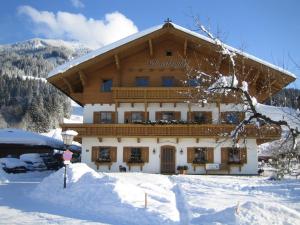 a large building in the snow in front at Schneeberghof in Westendorf
