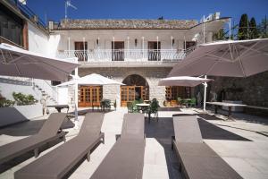 an outdoor patio with chairs and tables and umbrellas at villa il sogno di Cosimo in Ravello