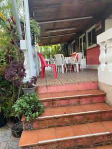a porch with red chairs and a table and chairs at pti caze Hoarau in Le Tampon +5 photos