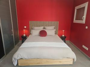a bedroom with a large bed with a red wall at Loft Casa Couderc Terrace Parking in Velaux