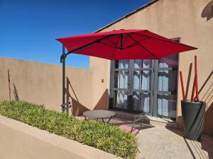 a red umbrella and a table in front of a building at Loft Casa Couderc Terrace Parking in Velaux