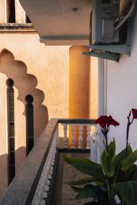 a house with a red flower on a balcony at Nyumbani Stonetown in Zanzibar City