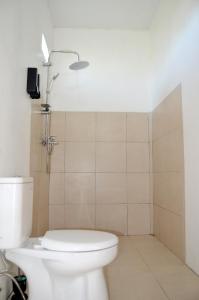 a bathroom with a white toilet and a shower at Rinjani inn Lombok in Tetebatu