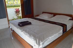 a bedroom with a large bed with a towel on it at Rinjani inn Lombok in Tetebatu