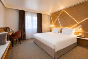 a hotel room with a large bed and a desk at Best Western Plus Paris Meudon Ermitage in Meudon +50 photos
