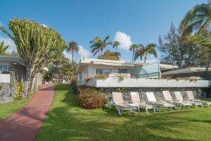 a row of chairs sitting in the grass in front of a house at Bull Costa Canaria & Spa - Only Adults in San Agustin