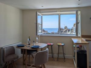 a dining room with a table and chairs and a window at Seaview Portland in Portland
