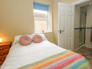 a bedroom with a bed with two pink pillows on it at Seaview Portland in Portland