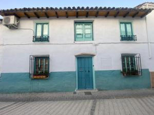 a white building with green doors and windows at Sigals Art B and More in Alcalá la Real