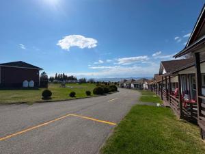 an empty road in front of a row of houses at Motel au Fleuve d'Argent in Rivière-du-Loup +18 photos