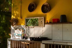 a kitchen with a counter and a yellow wall at Maraca Vibes Hostel in Porto De Galinhas