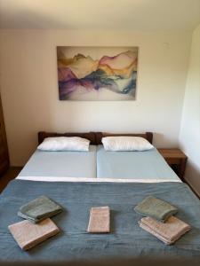 two beds in a room with towels on them at Bajic Apartmani in Seline