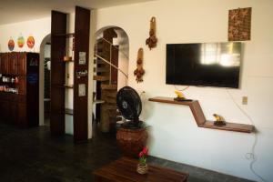 a living room with a flat screen tv on a wall at Maraca Vibes Hostel in Porto De Galinhas