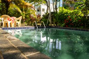 a swimming pool with a fountain in a yard at Maraca Vibes Hostel in Porto De Galinhas +28 photos