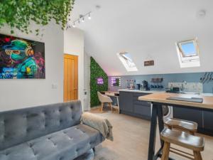 a living room with a couch and a kitchen at Upbeat Jungle Loft Apartment in Derby