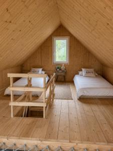 a room with two beds in a wooden house at Domek BrzozoweLove in Szczodrowo