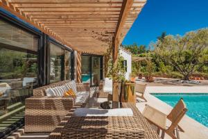 a patio with wicker chairs and a swimming pool at Villa avec piscine chauffée, proche Saint-Tropez et plages in Gassin