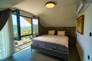 a bedroom with a bed and a large window at Skyline Skadar Lake in Karuč