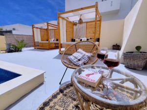 a table with two glasses of wine on a patio at Marina's Studios in Perivolos