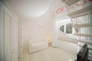 a white living room with a white chair and a window at La Settima Luna Hotel in Canneto +43 photos