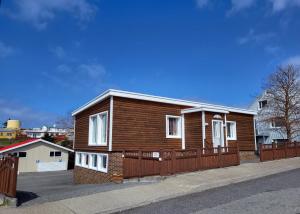 a small wooden house with a wooden fence at Holiday Guesthouse in Stykkishólmur