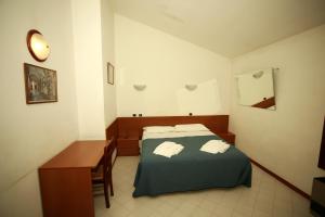 a bedroom with a bed and a desk with towels at Affittacamere San Cristoforo Faenza in Faenza +29 photos