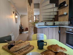 a table with bread and croissants on it in a kitchen at Les Chapeliers in Foix