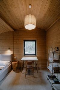 a room with a table and a bed and a window at УЛІС Віняви in Derevach