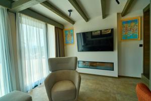 a living room with a chair and a television at Skyline Skadar Lake in Karuč