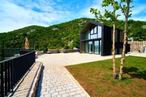 a black house with a mountain in the background at Skyline Skadar Lake in Karuč