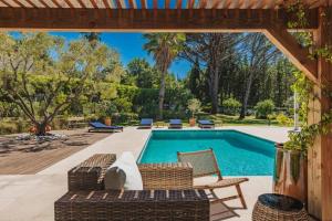 a swimming pool with a couch and chairs in a yard at Villa avec piscine chauffée, proche Saint-Tropez et plages in Gassin
