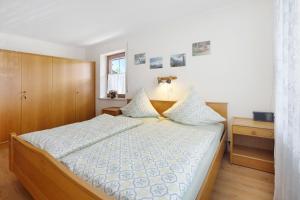 a bedroom with a bed with blue and white pillows at Haus Grüntensee in Wertach