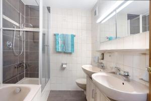 a bathroom with two sinks a toilet and a shower at Haus Grüntensee in Wertach +10 photos
