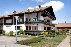 a large white building with a brown roof at Haus Grüntensee in Wertach