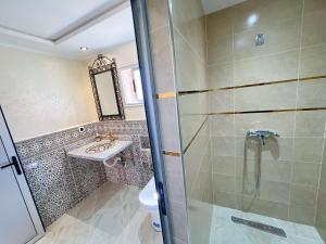 a bathroom with a shower and a sink at Hotel De La Vallée in Aït Baha