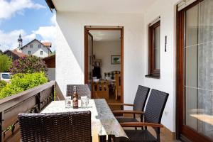 a patio with a table and chairs on a balcony at Haus Grüntensee in Wertach