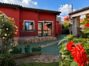 a red house with a green floor and a balcony at Los Tres Soles in Silleda