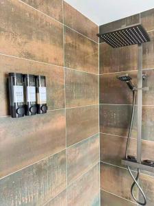 a shower with three bottles of soap on a wall at Trelawney in Coleraine +25 photos