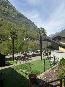 a playground with palm trees and a mountain in the background at Osteria Posse in Lavertezzo