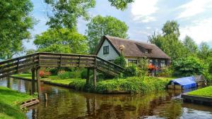 a house with a bridge over a river at Villa Oasis in Lelystad