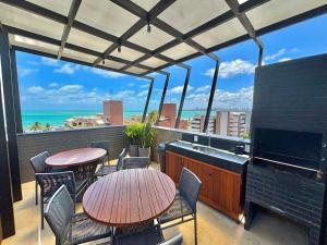 a balcony with tables and chairs and a piano at UMI Flats - Intermares by Refúgio Hospedagens in Cabedelo