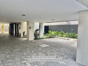 a lobby of a building with a courtyard with plants at UMI Flats - Intermares by Refúgio Hospedagens in Cabedelo