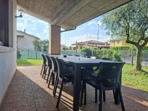 a black table and chairs under a roof at Villa Romea in Guidizzolo