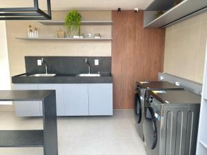 a bathroom with a sink and a washing machine at UMI Flats - Intermares by Refúgio Hospedagens in Cabedelo +43 photos