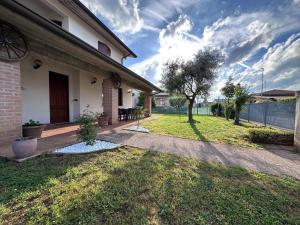 a backyard of a house with a grass yard at Villa Romea in Guidizzolo