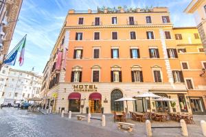 a large building with tables and umbrellas on a street at Hotel Accademia in Rome